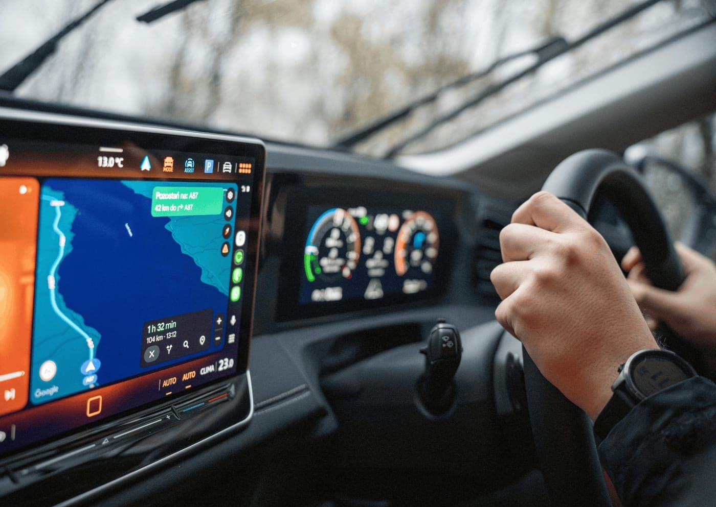 Driver at the wheel with the in-dash navigation screen and digital instrument cluster